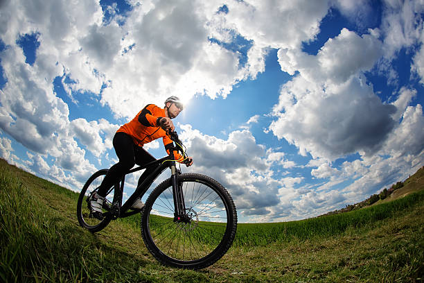 istock Young man cycling on a rural road through green meadow 577310738