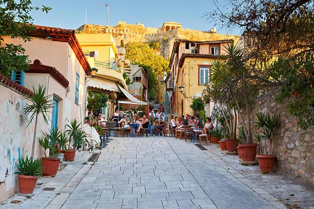Plaka, Athens. Athens, Greece – July 17, 2015: People in coffee shops in the old town of Plaka under Acropolis, Athens. Image was taken in the evening. plaka athens stock pictures, royalty-free photos & images