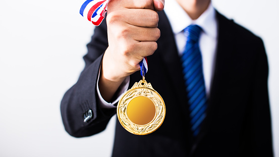 businessman holding gold medals