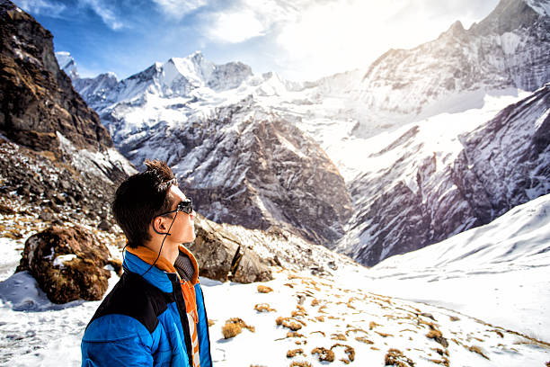 альпинист, глядя на высокие вершины вокруг него - annapurna range стоковые фото и изображения