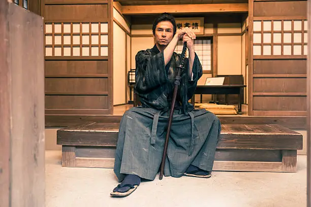 Samurai sat on a wooden bench meditating with his katana
