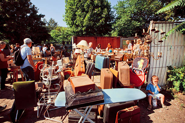 Berlin, Germany - August 30, 2015: Retro stuff, bags and utensils on sale with a crowd of shoppers of flea market on August 30, 2015. Urban area of Berlin comprised 4 mill. people, 7th most populous in EU