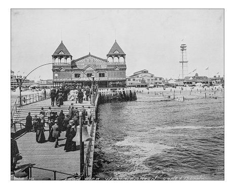 Antique photograph of West Brighton Beach resort (Coney Island,Brooklyn,New York City, USA) in a picture dating back to the late 19th century depicting people walking along the pier and toward the Beach pavilion.
