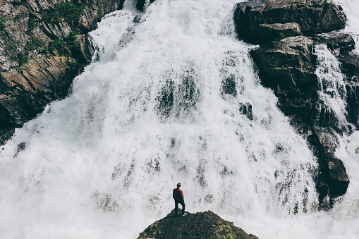 Man standing  on the background of the waterfall