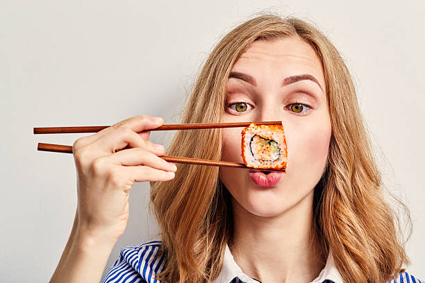 istock woman eating sushi 577322062