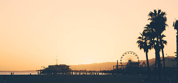 playa y muelle de santa mónica al atardecer - santa monica pier beach panoramic santa monica fotografías e imágenes de stock