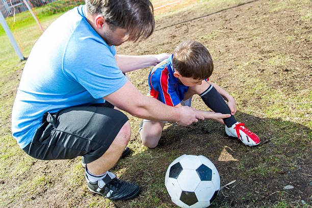 istock man with  child playing football on  pitch 577326650