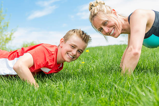 istock Happy son and mother are doing exercises in the summer 577328384
