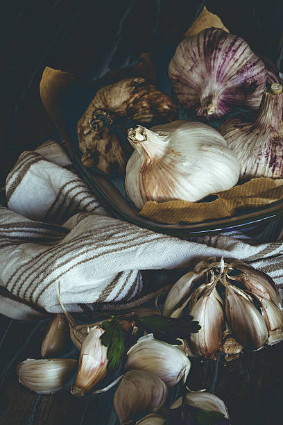 istock Purple garlics on a napkin on a wooden rustic table 577329220