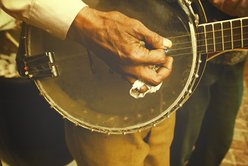 A man with bandaged finger plays the banjo