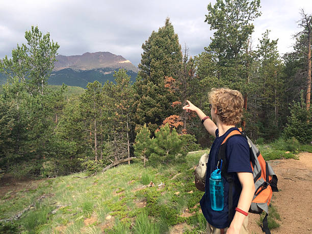 Young Male hiker points to Pikes Peak Mountain his destination stock photo
