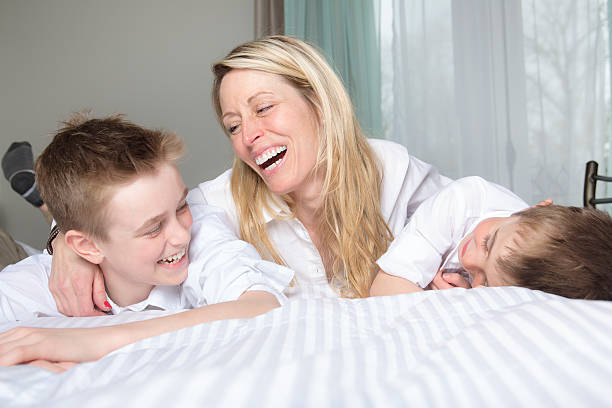 istock Mother And two Son Relaxing Together In Bed 577341216