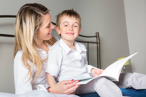 istock mother and her son reading book in a bed 577341426