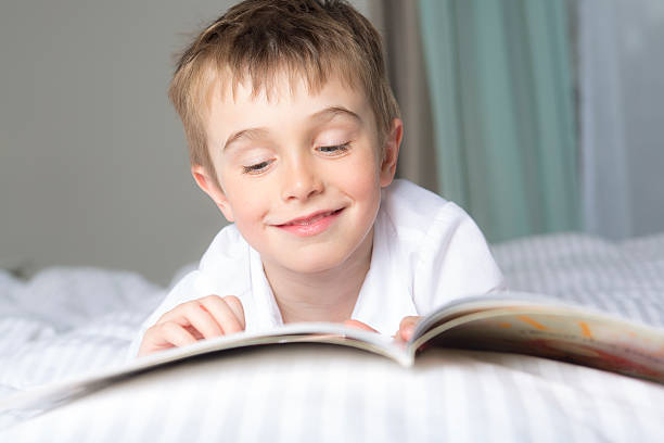istock little boy reading before dream in his bed 577341536