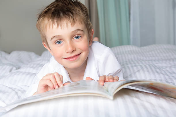 istock little boy reading before dream in his bed 577341560