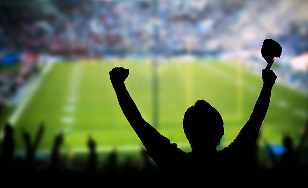 istock Man Raising Arms in Excitement at Sporting Event 577345718