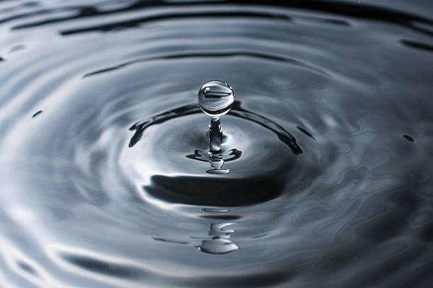 istock Splash of dark water with droplet from small a drip 577345850