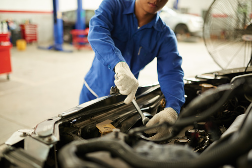 Cropped image of mechanic checking car transmission