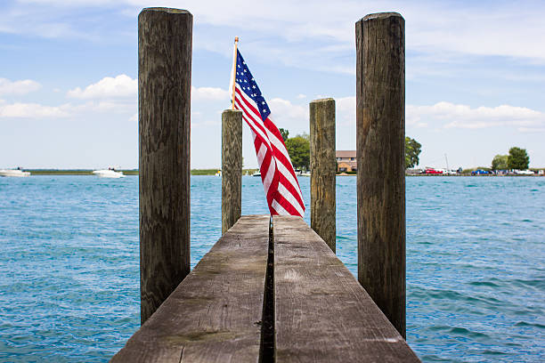 bandera estadounidense en un hulk con cielo azul y lago - star spangled banner fotografías e imágenes de stock