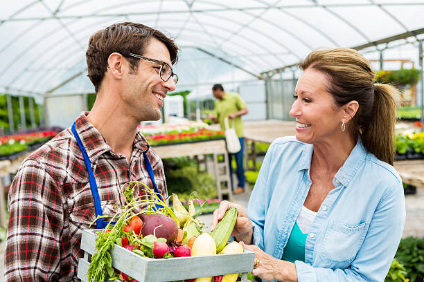 istock Mid adult farmer talks with customer about fresh produce 577348436