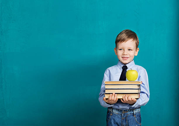 istock Cheerful smiling little kid against chalkboard. 577349792