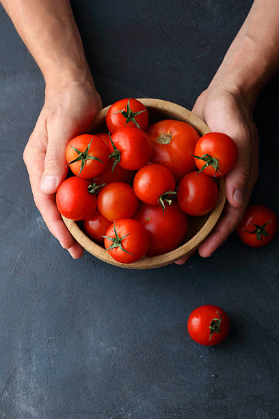 istock ripe tomatoes in wooden bowl 577350166