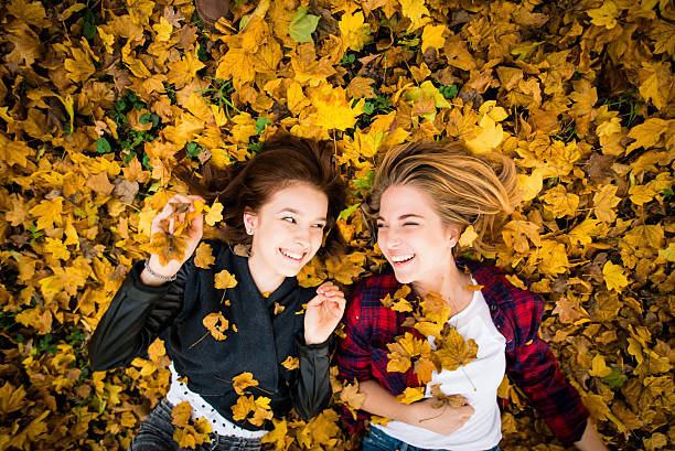 Friends having fun in leaves stock photo