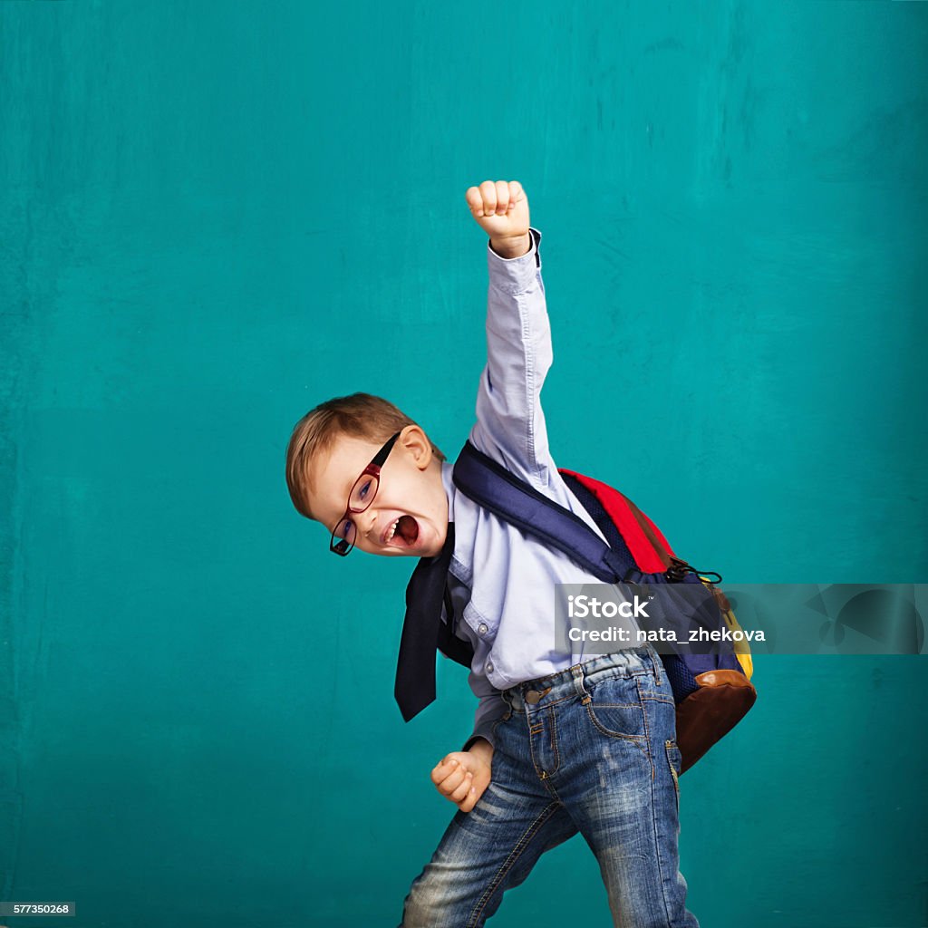 niño sonriente con una mochila grande saltando y divirtiéndose - Foto de stock de Niño libre de derechos