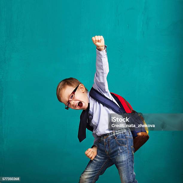 Niño Sonriente Con Una Mochila Grande Saltando Y Divirtiéndose Foto de stock y más banco de imágenes de Niño