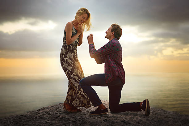 when her love brings you to your knees, marry her - engagement ring imagens e fotografias de stock