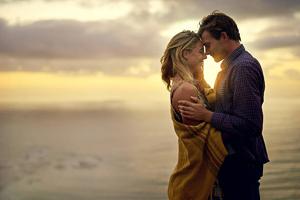 Love that speaks to the soul Shot of an affectionate young couple sharing a tender moment at sunset flirty stock pictures, royalty-free photos & images