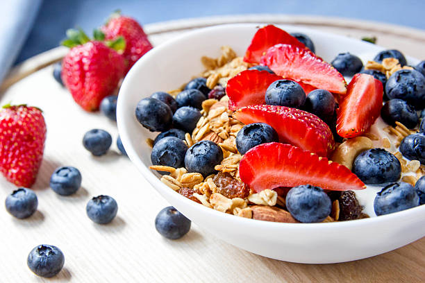 istock Granola with blueberries and strawberries in the white bowl. 577621394