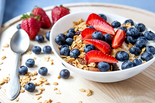 istock Granola with blueberries and strawberries in the white bowl. 577621466