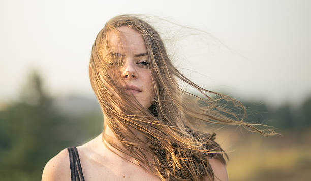 schönes mädchen am windigen tag - smiling women blond hair human face stock-fotos und bilder