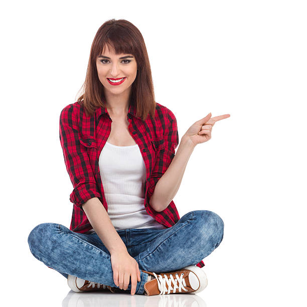 istock Girl Sitting On A Floor And Pointing 577629780