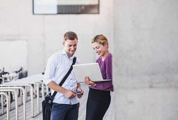 istock Business Couple Discussing and Using Portable Devices 577630906