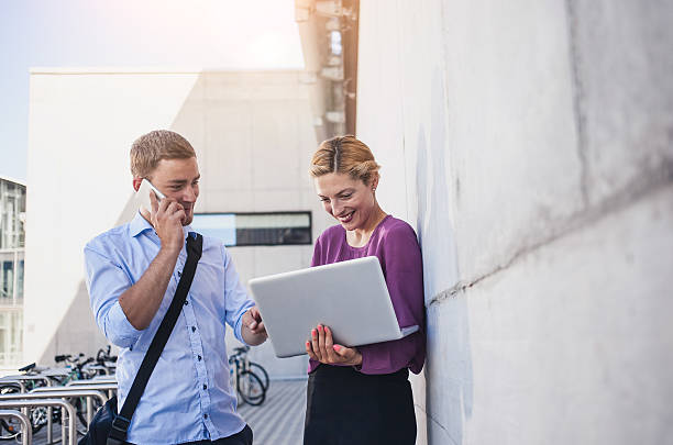 istock Business Couple Discussing and Using Portable Devices 577630986