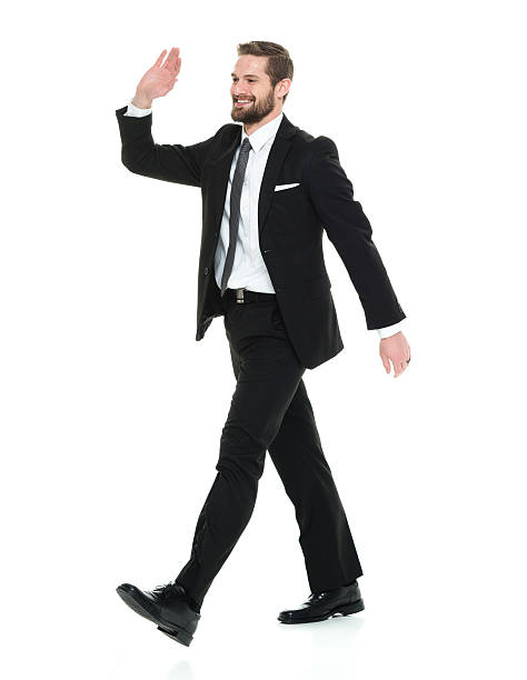 istock Smiling businessman walking and waving hand 577634984