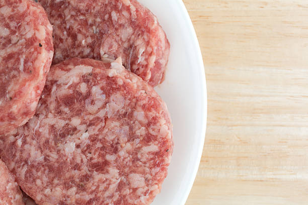 istock Sausage patties on a white plate atop a table 577637226