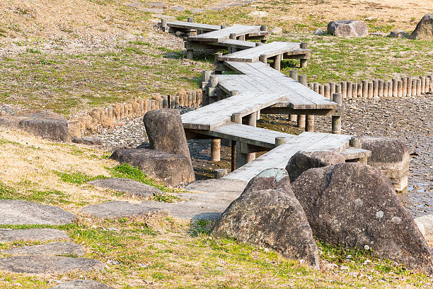 istock wooden bridge zigzagging on dry pond with drought. 577637498