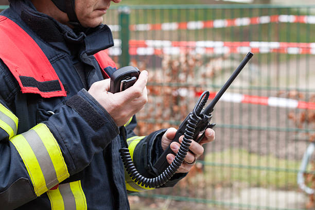 bombero en acción con walkie takie en la mano - alarma de incendio fotos fotografías e imágenes de stock