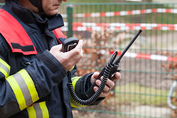 pompier en action avec un walkie takie à la main - walkie talkie photos et images de collection