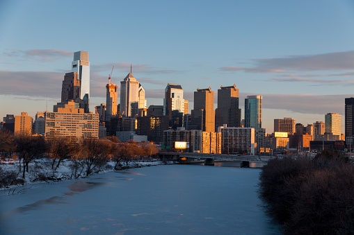 All of Philadelphia covered in snow after winter 2016 snow storm, Schuylkill river completely frozen and downtown skyline on the background during sunset.