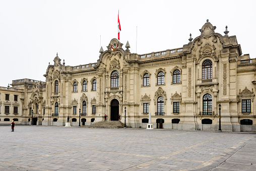 Lima, Peru - June 12, 2016: Government Palace, the official residence and office of Peru's president, is located next to the Plaza de Armas or central plaza of Lima. Back in the time of the Incas, the site had strategic and spiritual meaning, which is why the last Inca chief in Lima also lived here. Pizarro, the conqueror of the Incas, so liked the site that he kept it for the first Spanish palace, whose construction began in 1535. Since then, Government Palace has been rebuilt numerous times; the current French-inspired mansion was constructed in the 1930s. Guards stand watch over the main entrance.