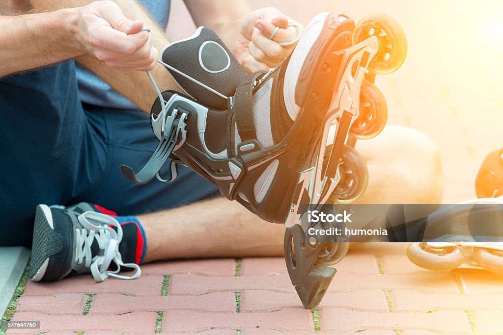 Man preparing for roller blading, Man preparing for roller blading, putting on rollerblades. Active Lifestyle Stock Photo