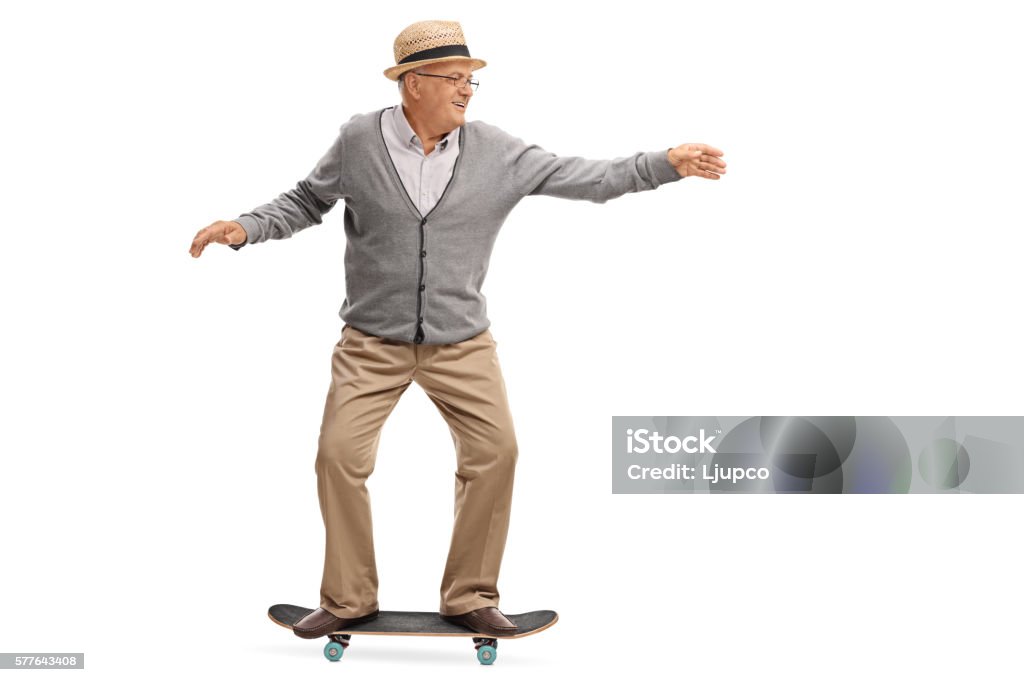 Joyful senior man riding a skateboard Joyful senior man riding a skateboard isolated on white background Senior Adult Stock Photo