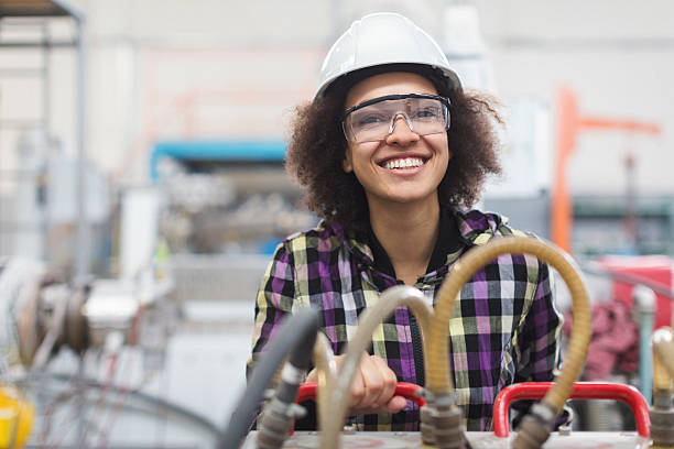 istock Female worker operating a machine and smiling for the camera 577645680