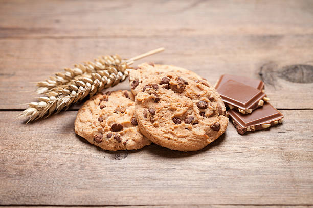 istock Chocolate cookies and wheat on old wooden table 577646582