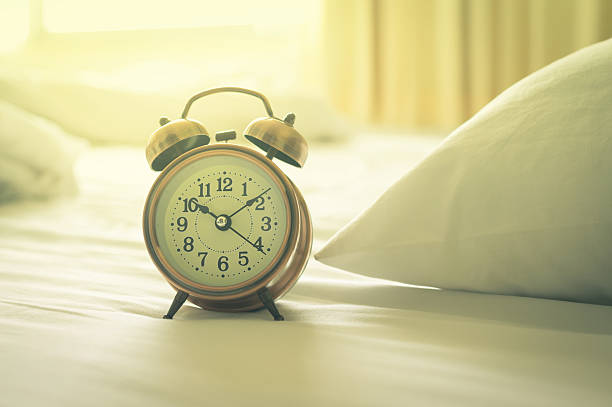 istock Alarm clock on bed,vintage filtered. 577647408