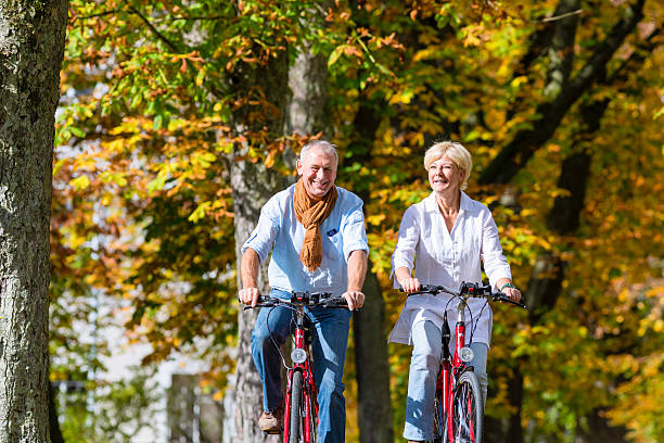 istock Seniors on bicycles having tour in park 577647510